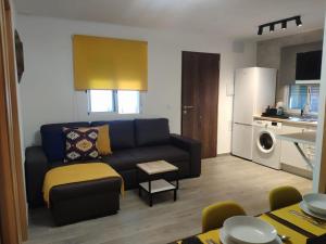 a living room with a couch and a kitchen at Novoasis in Chiclana de la Frontera