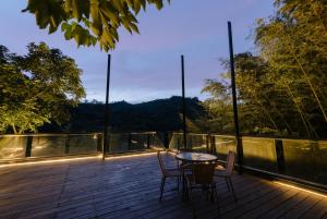 a patio with a table and chairs on a deck at Zhou Ye Cottage in Sanyi