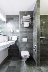 a bathroom with a toilet and a sink and a shower at Bastion Hotel Den Haag Rijswijk in Rijswijk