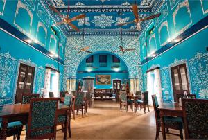 una sala da pranzo con pareti e tavoli blu e sedie di Bloom Boutique l A Heritage Property at Lake Pichola a Udaipur