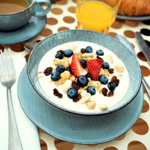 un bol de yogur con frutas y frutos secos en Condominio Monti Boutique Hotel, en Roma