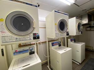 uma lavandaria com três máquinas de lavar roupa e arruelas em Koriyama View Hotel em Koriyama