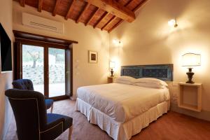 a bedroom with a bed and a chair and a window at Podere di Moiata in Campestri