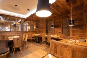 a restaurant with wooden walls and tables and chairs at Hotel Adler - Paulas Alb in Ehingen