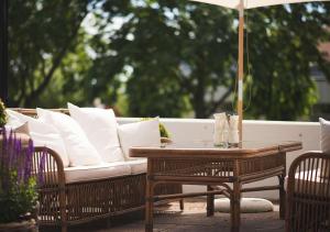 a white couch sitting under an umbrella on a patio at Hotel Bellevue in Hjo
