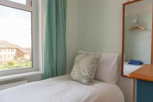 a bedroom with a bed with a mirror and a window at Pilgrim's Lookout Whitstable Holiday Home in Whitstable