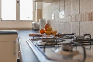 a kitchen counter with a stove with fruit on it at Pilgrim's Lookout Whitstable Holiday Home in Whitstable
