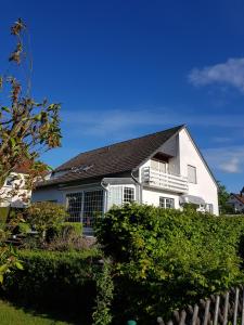 a white house with a black roof and bushes at Ferienhaus Anja Bad Pyrmont in Bad Pyrmont