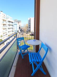 Duas cadeiras azuis e uma mesa na varanda em Mini Hotel em Rimini