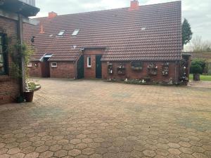 a large brick house with a large roof at Ferienwohnung Hage in Hage