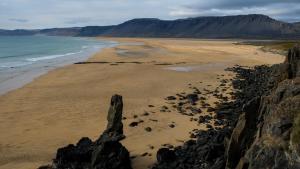 a view of a beach with rocks and the ocean at Harbour Inn - Guesthouse in Bíldudalur