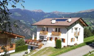 a white house with a view of mountains at Agrotourismus Ferienhof Gschloier in Laion