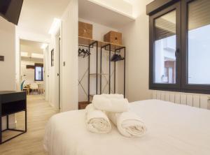 a bedroom with a white bed with towels at Mirasol apartament en Bilbao la vieja by Urban Hosts in Bilbao