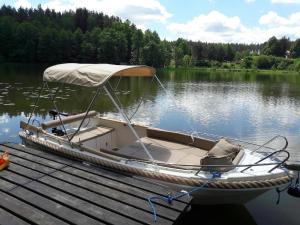 a small boat tied up to a dock on a lake at Chata Warmińska in Łajs