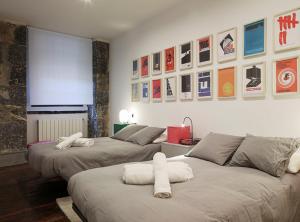 twee bedden in een kamer met posters aan de muur bij Casco Viejo Comodidad y elegancia by Urban Hosts in Bilbao