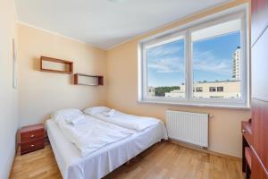 1 dormitorio con cama y ventana grande en Apartamenty Sun & Snow Międzyzdroje Aquamarina, en Międzyzdroje