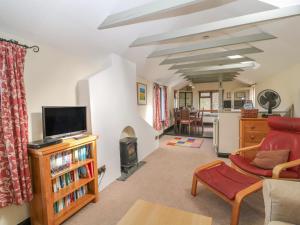 a living room with a couch and a tv at Springfield Cottage in Bideford