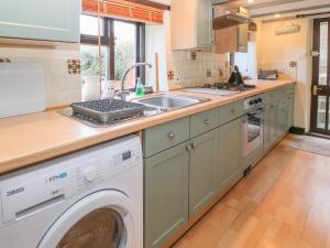 a kitchen with a washing machine and a sink at Springfield Cottage in Bideford