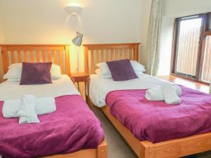two beds sitting next to each other in a bedroom at Springfield Cottage in Bideford