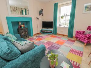 a living room with a blue couch and a tv at Adams House in Eyemouth