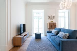 een woonkamer met een blauwe bank en een tv bij FLH Restauradores Bright Flat in Lissabon +8 foto's
