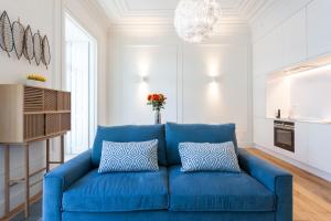 a blue couch with two pillows in a living room at FLH Restauradores Bright Flat in Lisbon