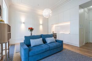 een woonkamer met een blauwe bank en een keuken bij FLH Restauradores Bright Flat in Lissabon
