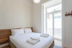 een slaapkamer met een bed met handdoeken erop bij FLH Restauradores Bright Flat in Lissabon