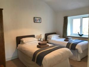 two beds in a room with a window at Seaview Cottage in Aberdyfi