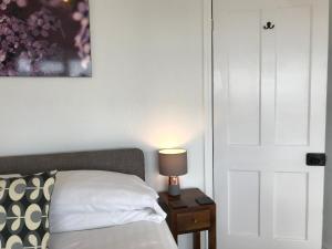a bedroom with a bed and a lamp on a night stand at Seaview Cottage in Aberdyfi