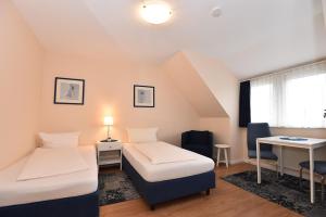 a room with two beds and a desk and a table at Bremer Apartmenthotel Superior in Bremen