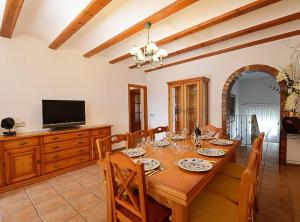 a dining room with a wooden table and a television at Villa Iris - Plusholidays in Calpe