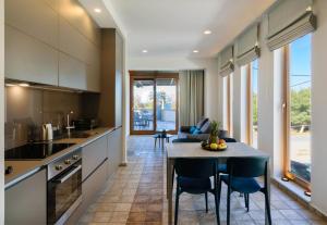 cocina y comedor con mesa y sillas en Xenios Dias Luxury Apartments With Sea View, en Kato Daratso