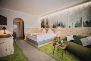 Cette chambre comprend un lit, un canapé et une table. dans l'établissement Gasthof Berghof, à Semmering