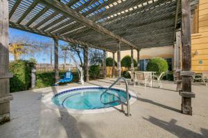 einen Pool auf einer Terrasse mit einer Pergola in der Unterkunft La Quinta by Wyndham DFW Airport South / Irving in Irving
