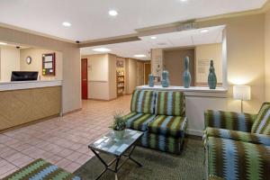 a waiting room with two chairs and a table at La Quinta Inn & Suites by Wyndham Sawgrass in Sunrise