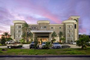 un gran edificio con coches estacionados en un estacionamiento en La Quinta by Wyndham Houston Willowbrook, en Houston