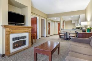 a living room with a fireplace and a tv at Comfort Inn Blythewood - North Columbia in Blythewood