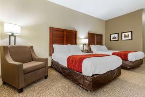 a hotel room with two beds and a chair at Comfort Inn & Suites Clemson - University Area in Clemson