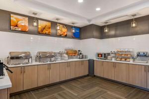 a kitchen with wooden cabinets and aasteryasteryasteryasteryasteryasteryasteryasteryastery at Comfort Suites Stuart-Hutchinson Island in Stuart