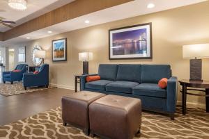 uma sala de estar com um sofá azul e uma mesa em Comfort Inn em Pearl