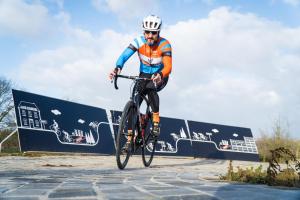 un hombre montando una bicicleta en un camino en Café Coureur Borgloon en Borgloon