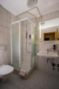 uma casa de banho com um chuveiro, um WC e um lavatório. em Ferienwohnungen Chiemgauer Seenglück em Obing