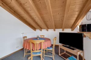 a dining room with a table and a tv at Petrushof Ferienwohnung Hochplatte in Oberwössen