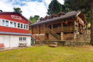 una gran casa de madera con techo rojo en Srub Midla a chata Bondovka, en Čenkovice