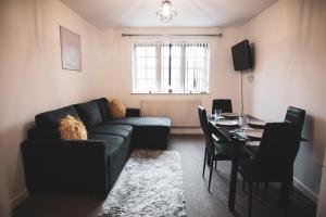 a living room with a couch and a table at Asha Court Serviced Apartments in Worcester