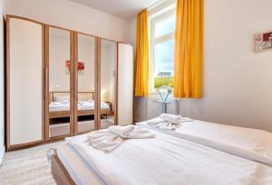 1 Schlafzimmer mit 2 Betten und einem großen Spiegel in der Unterkunft Haus Meerblick - 10 in Ahlbeck