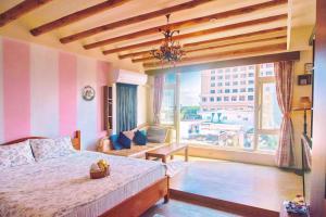 花蓮市にあるSeville Countrified B&Bのベッドと大きな窓のある寝室