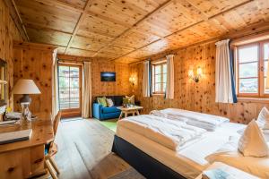 a bedroom with a large bed in a room with wooden walls at Grossarler Hof Superior in Grossarl