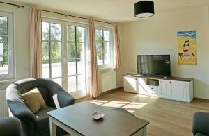 a living room with a television and a table at Baabe Inselparadies Fewo Sandbank in Baabe